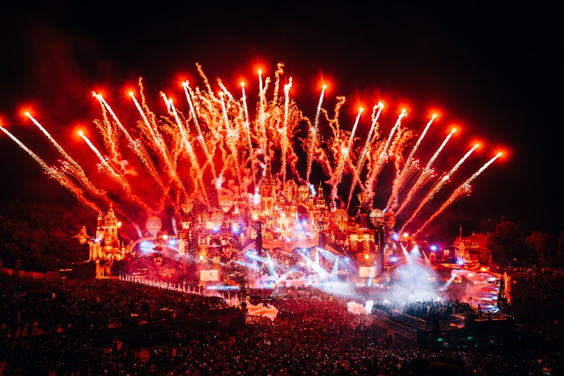 Red firework fountains above an ornate fairytale castle stage at night