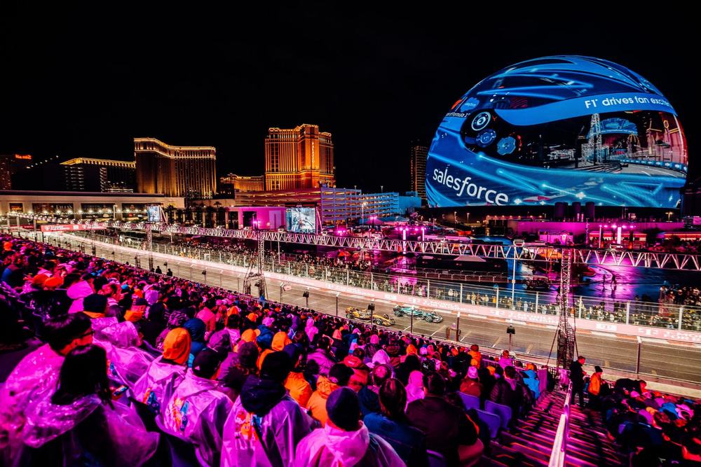 Grandstand crowd at the Formula 1 Las Vegas Grand Prix with the Sphere glowing in the background