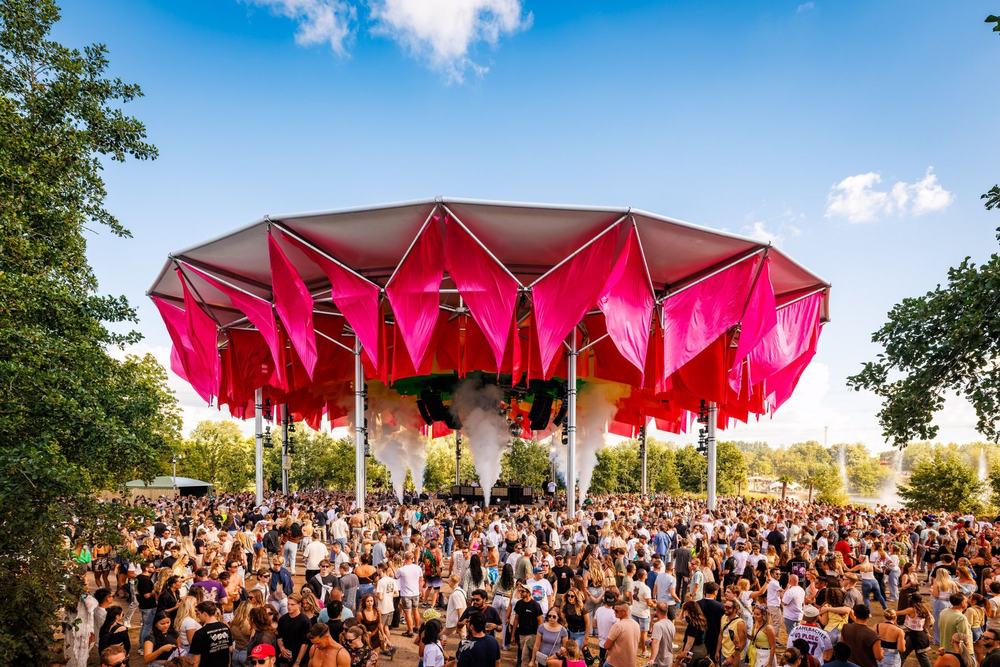 Pink canopy stage with a crowd in the sunshine