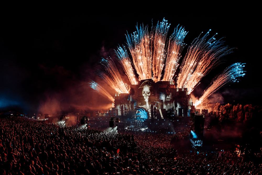 Fireworks fanning out above a festival stage at night