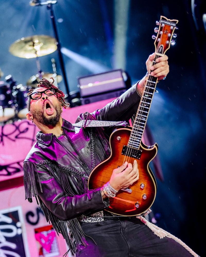 Guitarist in mid-solo under blue stage light