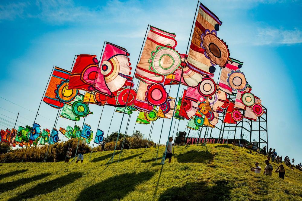 Colourful festival flags on a hill under a blue sky