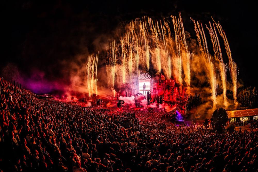 Fireworks fanning out behind the Mysteryland stage over a huge crowd