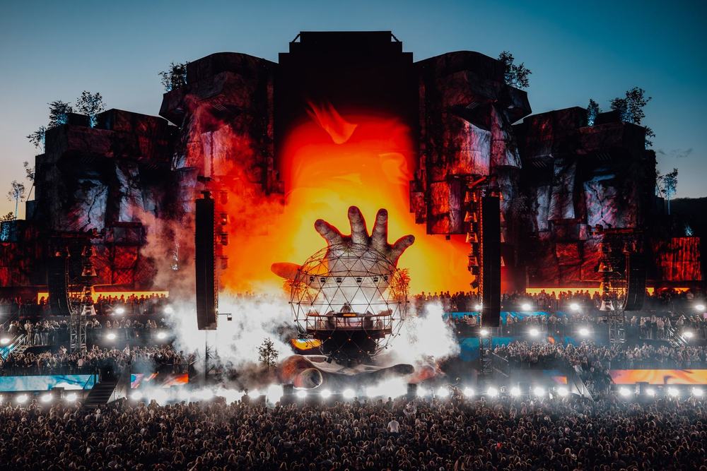 Mysteryland stage with a giant glowing hand at dusk